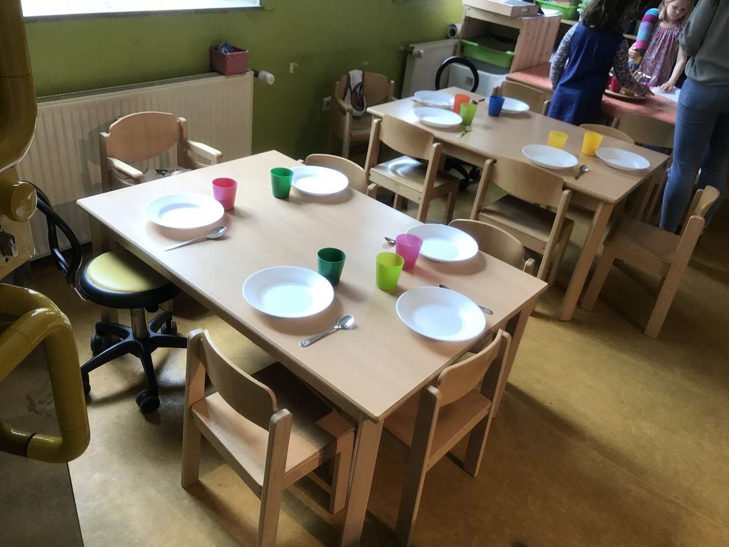 Kinder und Erziehende beim gemeinsamen frisch zubereiteten Mittagessen